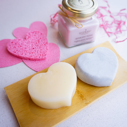 2 heart shaped shampoo and conditioner bars with pink facial sponges