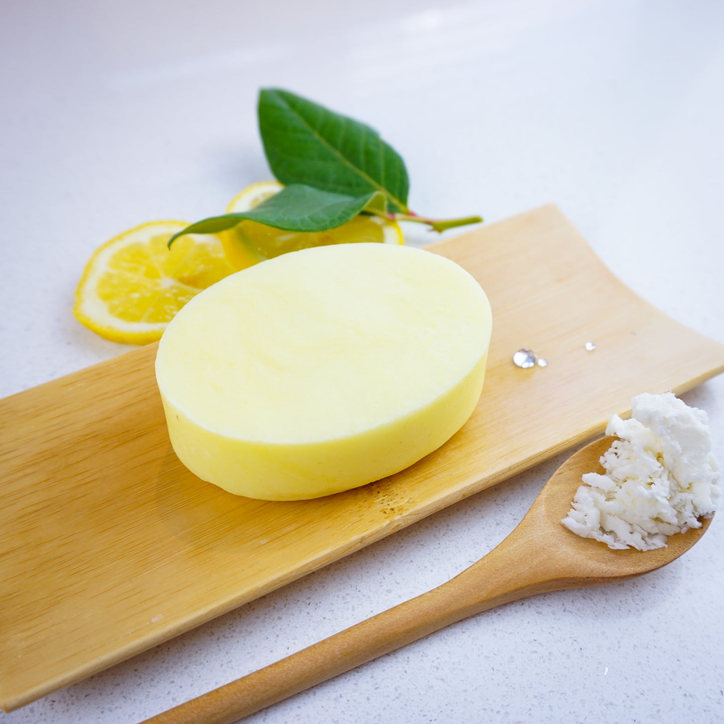 Washla Hydrating Lemon Shampoo bar with shea butter sitting on a bamboo tray