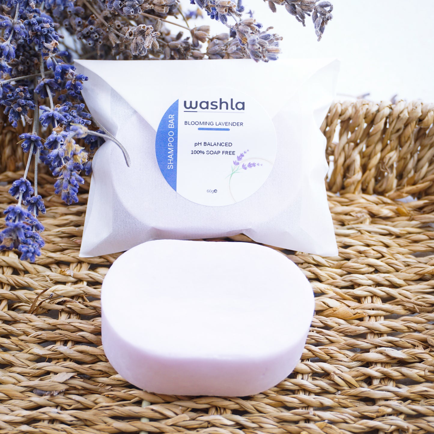 Washla Lavender 60g Shampoo Bar wrapped sitting on basket hamper