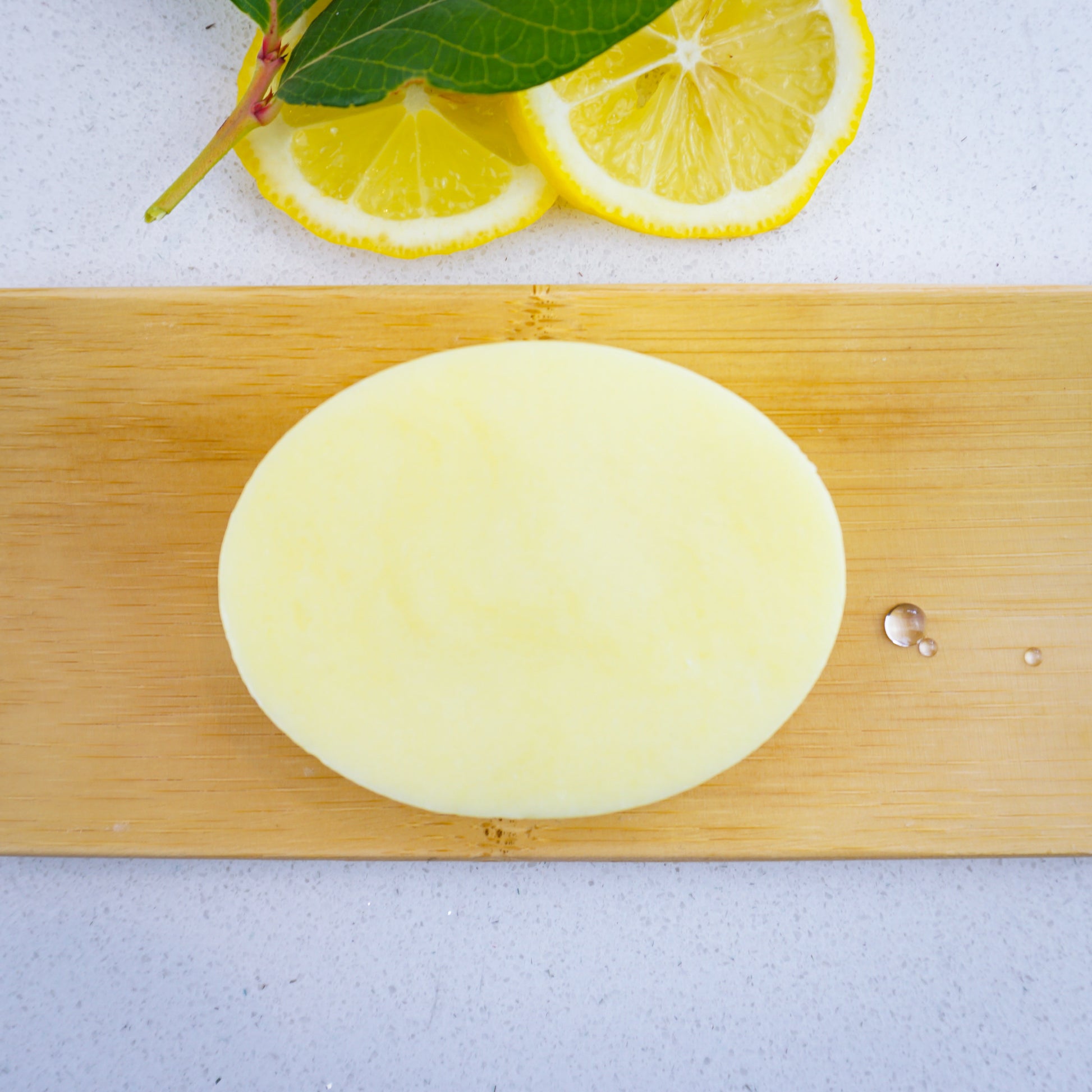 Washla Lemon Shampoo bar sitting on bamboo tray with droplets