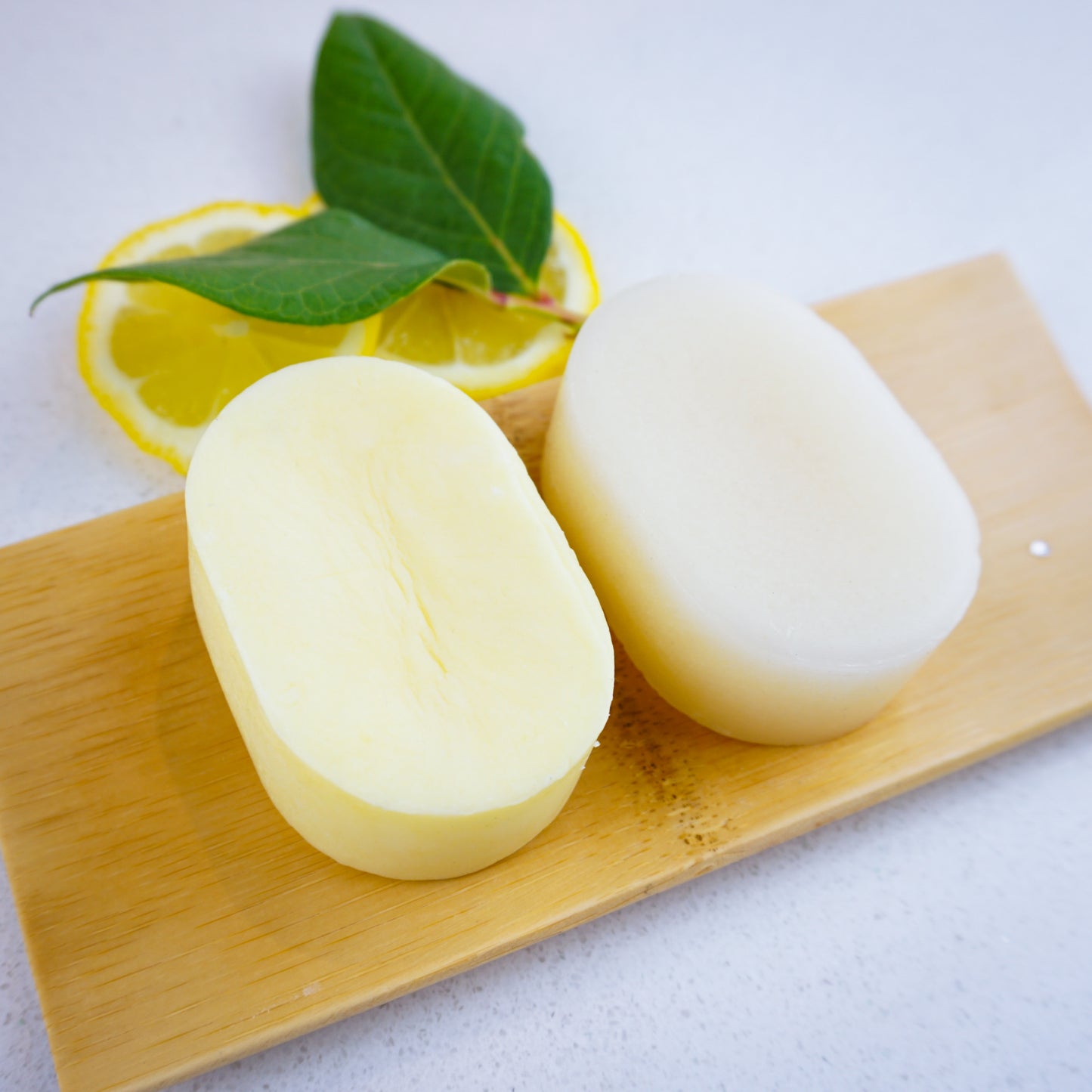 Lemon shampoo and conditioner bars set on bamboo tray