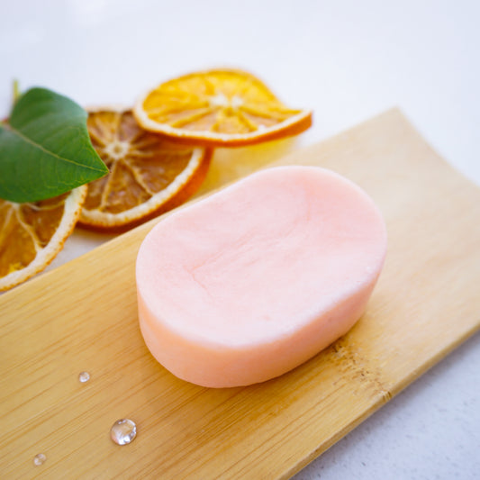 Washla 60g Orange shampoo bar on bamboo tray with dried orange slices