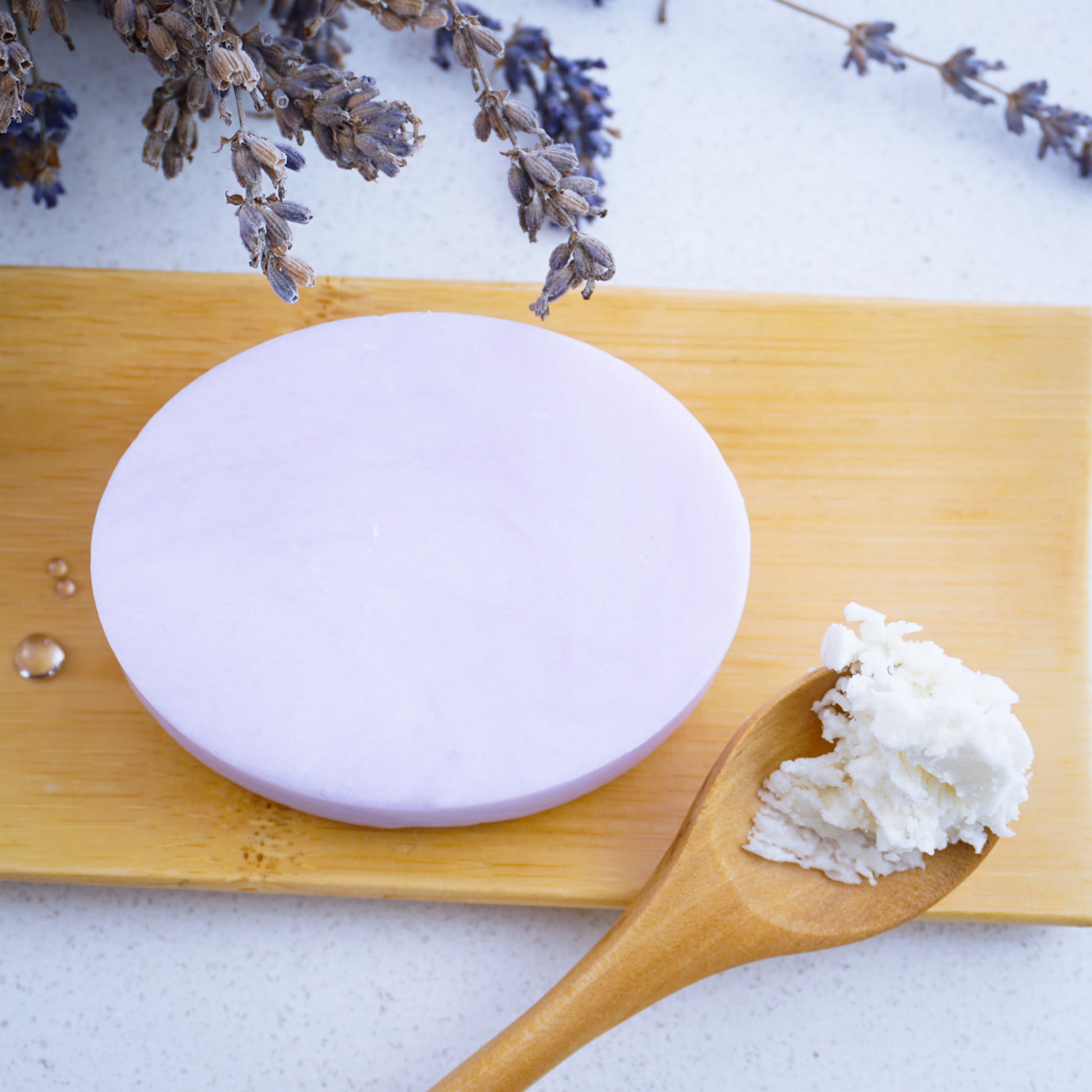 Unwrapped lavender hydration shampoo bar on a bamboo tray