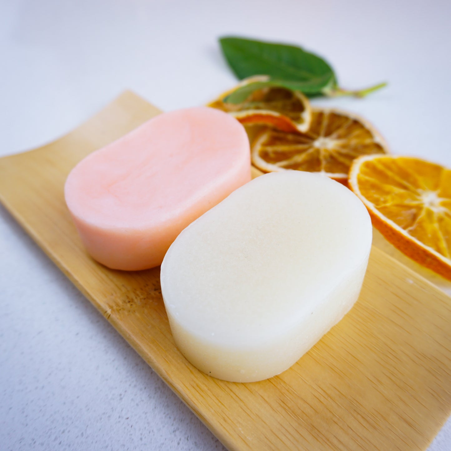 orange shampoo and conditioner bars on a bamboo tray
