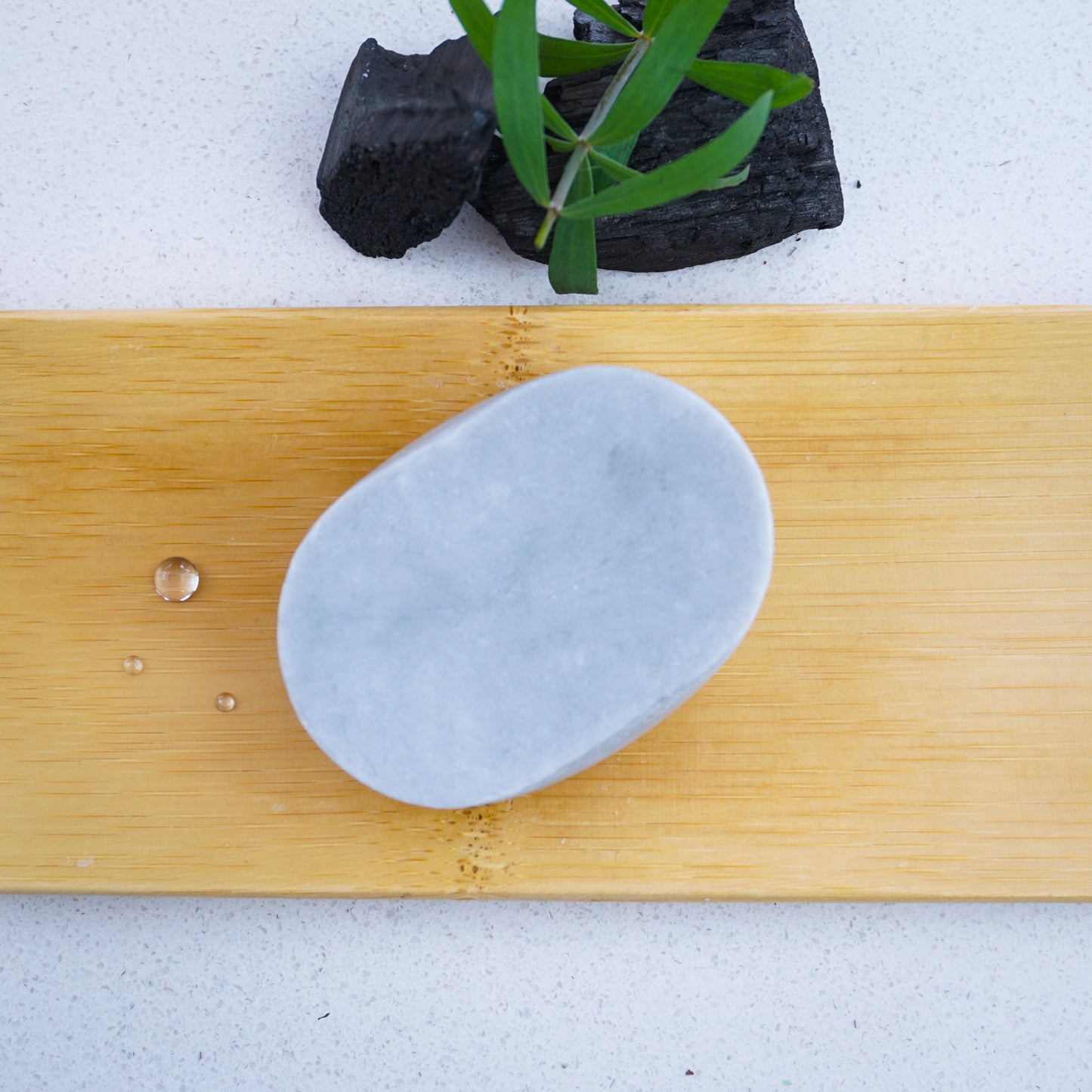 Washla 60g Shampoo bar Tea tree and charcoal on bamboo tray with droplets