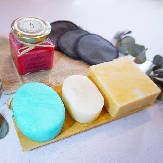Peppermint shampoo and conditioner bar on a bamboo dish. A scented candle and facial wipes in the background