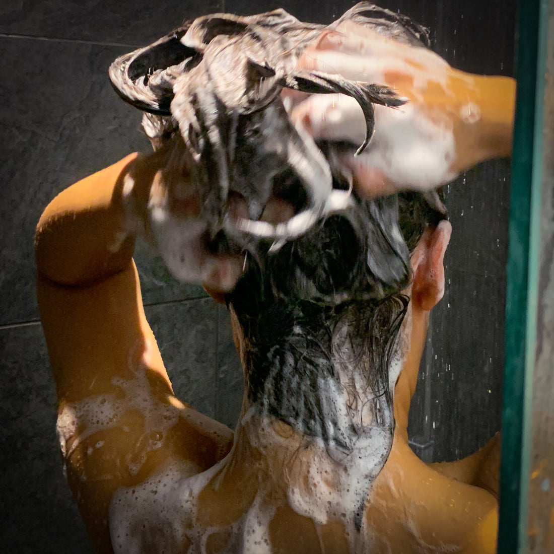 A person washing her hair with shampoo bar