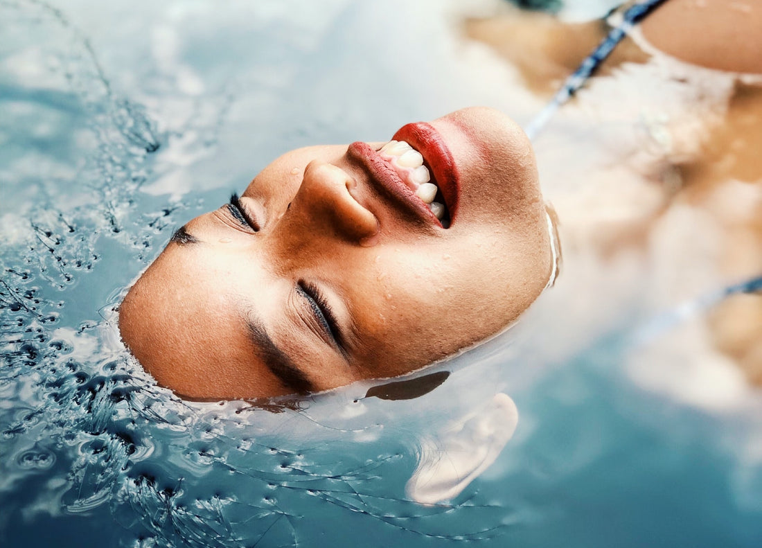 A woman on her back swimming in water.