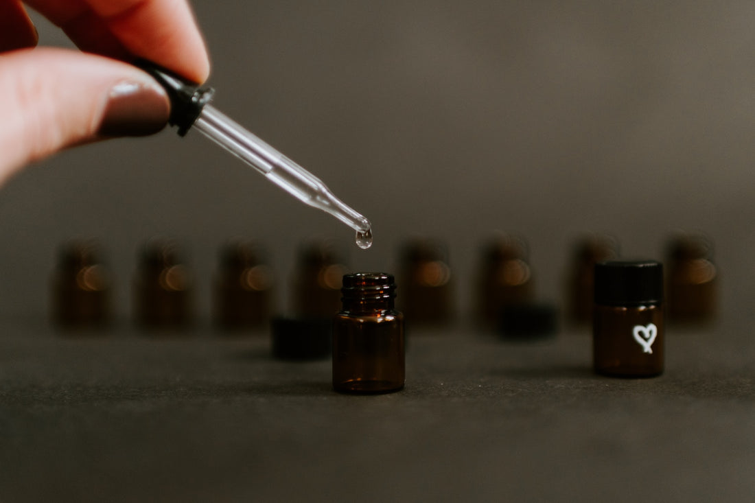 A dropper dripping essential oils in to small bottles