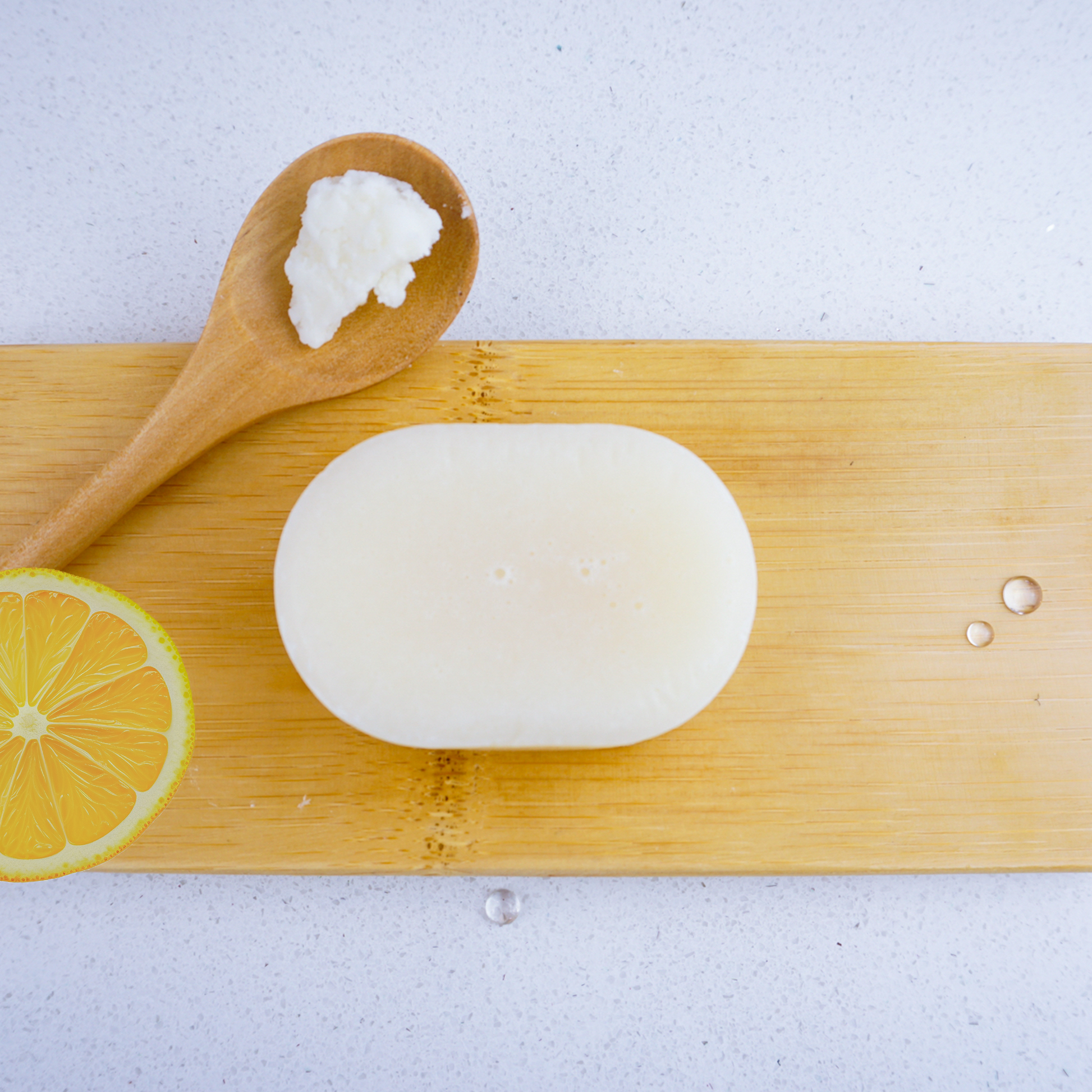 Washla lemon conditioner bar next to a wooden spoonful of shea butter