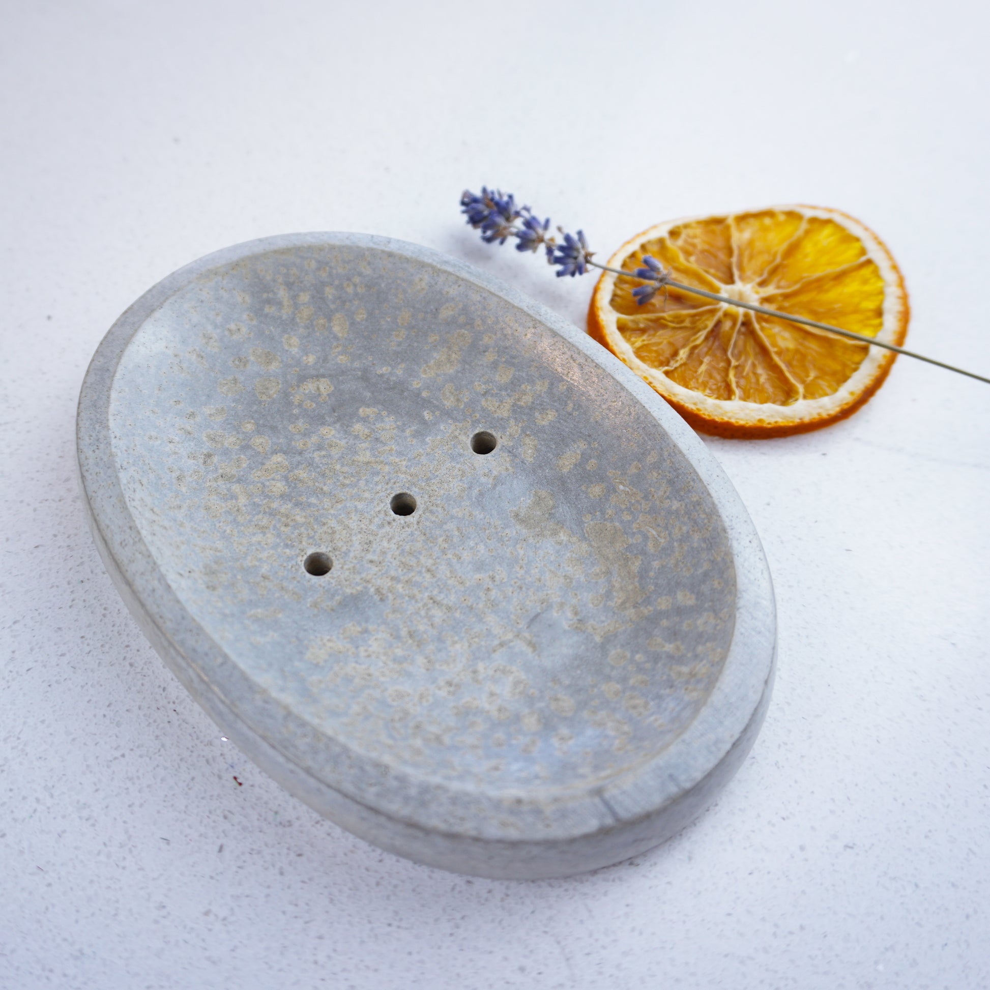 Concrete dish with lavender and orange sitting beside it for decoration