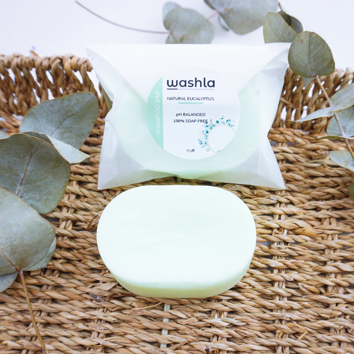 Washla 60g Eucalyptus Shampoo bar on hamper tray with eucalyptus leaves