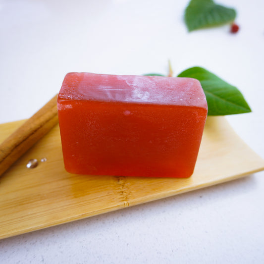 Honey and vanilla and cinnamon soap bar with droplets and green leaves behind