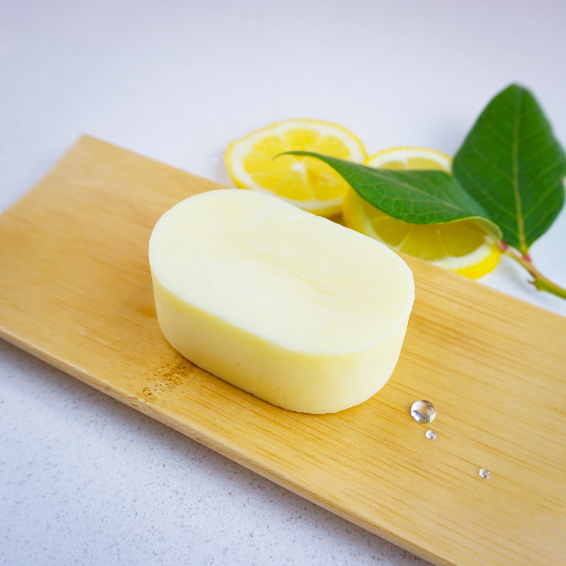 Washla 60g Lemon shampoo bar on bamboo tray with fresh lemon slices for decoration