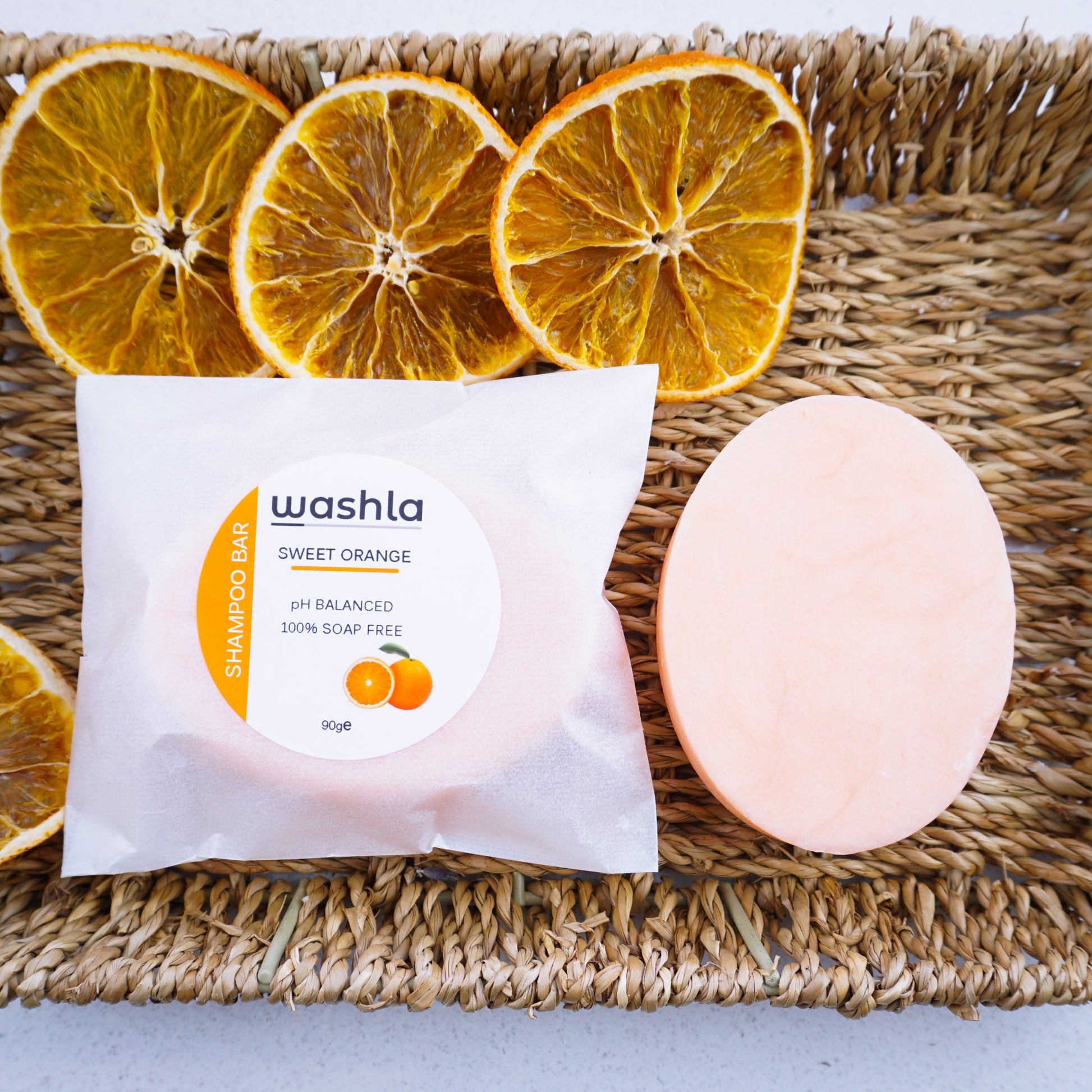 Washla Orange shampoo bar wrapped and an unwrapped bar
